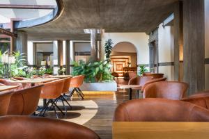 フィレンツェにあるホテル クローチェ ディ マルタのテーブルと椅子、植物のあるレストラン