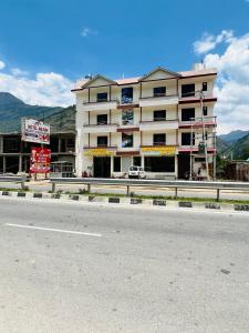 a large building on the side of a road at Hotel Anjum Regency in Bajaura