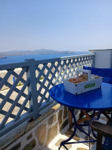 una caja de comida en una mesa azul en un balcón en Traditional house under the castle en Astipalea