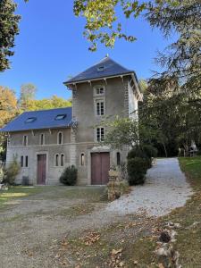 ein großes Steinhaus mit blauem Dach in der Unterkunft la Tour du Grand DUC in Cenne-Monestiès