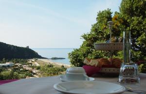 a table with a plate of food and a view of a beach at La Formica in Ascea