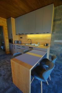 a kitchen with a sink and a counter with chairs at Apartmán A1 Hrabušice in Hrabušice