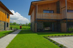 una casa con un césped verde delante de ella en Apartmán A1 Hrabušice, en Hrabušice