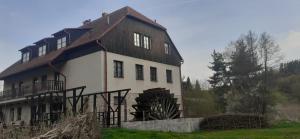 uma grande casa branca com um telhado de madeira em Kratochviluv mlyn em Červená Lhota