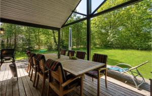een houten tafel en stoelen op een terras bij Cozy Home In Give With Kitchen in Give