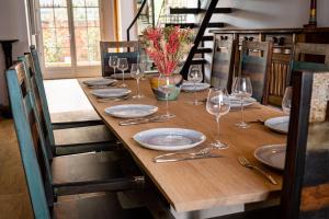 - une longue table en bois avec des assiettes et des verres à vin dans l'établissement 23, à Soulac-sur-Mer