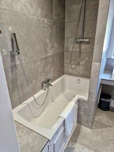 La salle de bains est pourvue d'une baignoire blanche et d'une douche. dans l'établissement 18 Horner Street, à York