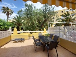 een patio met een tafel en stoelen en een hek bij Bungalow Alkabir Playa in El Campello