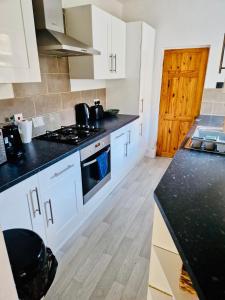 a kitchen with white cabinets and a black counter top at 18 Horner Street in York