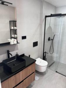 y baño con lavabo, ducha y aseo. en Apartamentos Kouohana, en Fuengirola