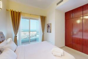 a bedroom with a large white bed and a large window at The Zen Tower - Vacationer in Dubai