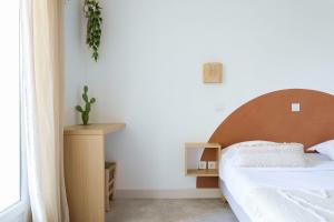 1 dormitorio con 1 cama con cabecero de madera y mesa en Le Relais d'Agay, en Agay - Saint Raphael