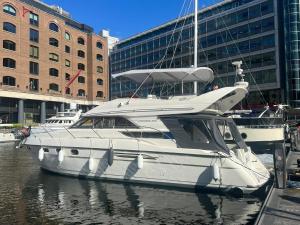 a white boat is docked in the water at Yacht -Central London St Kats Dock Tower Bridge in London