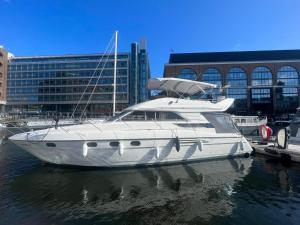 un barco blanco está atracado en un puerto en Yacht -Central London St Kats Dock Tower Bridge, en Londres