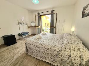 1 dormitorio con cama con edredón en Vintage Home, en La Caletta 5 fotos más