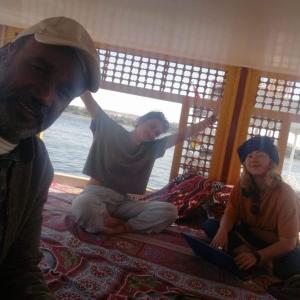 a group of people sitting on the floor with a laptop at Sailing boat in Aswan