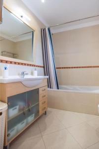 a bathroom with a sink and a mirror and a tub at Apartment Quinta das Salinas -Great Views in Almancil