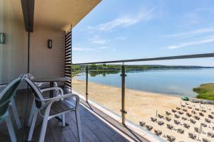 a balcony with a view of the water at Antonińska Resort SPA in Boszkowo