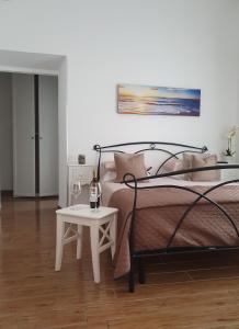 Un dormitorio con una cama y una mesa con una botella de vino en Guest house al mare en Civitavecchia