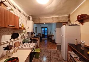 a kitchen with a white refrigerator and a living room at Habitaciones en El Atico de Tona mirando a la Bahia de Santander in Santander