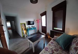 ein Wohnzimmer mit einem Sofa und einem Tisch in der Unterkunft Habitaciones en El Atico de Tona mirando a la Bahia de Santander in Santander