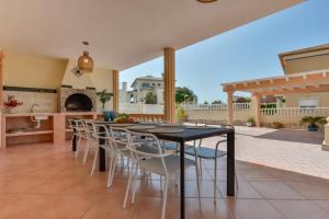Villas Guzman - BELLISSIMA في كاليبي: مطبخ وغرفة طعام مع طاولة وكراسي