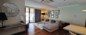 a living room with a couch and a clock on the wall at Poblacion Penthouse Suite with Private Roofdeck in Manila