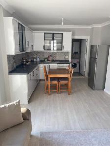 een keuken met een houten tafel en een keuken met een koelkast bij Marina dairesi in Çeşme