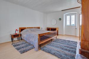 Schlafzimmer mit einem Bett, einem Tisch und einem Teppich in der Unterkunft Stonehouse Mali Lukoran in Lukoran