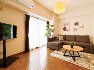 a living room with a couch and a tv at OUCHI HOTEL Dambara in Hiroshima