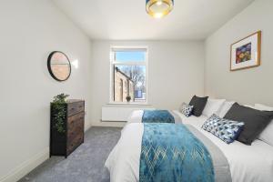 1 dormitorio con 2 camas y ventana en A selection of apartments in Golborne Business and Leisure WIFI Parking by Stone Pit Apartments en Golborne