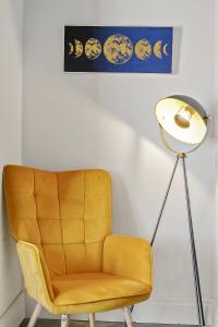 a yellow chair and a lamp in a room at A selection of apartments in Golborne Business and Leisure WIFI Parking by Stone Pit Apartments in Golborne