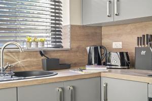 a kitchen with a sink and a counter top at A selection of apartments in Golborne Business and Leisure WIFI Parking by Stone Pit Apartments in Golborne