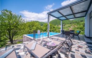 a patio with a table and chairs and a swimming pool at 4 Bedroom Nice Home In Ivancici 
