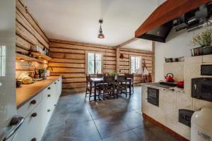 Dom pod Lipami في Bachórz: مطبخ بجدران خشبية وطاولة وكراسي