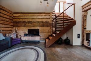 a living room with a wooden wall and a staircase at Dom pod Lipami in Bachórz