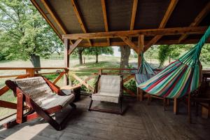 a porch with a hammock and chairs on it at Dom pod Lipami in Bachórz