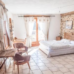 La Fernande في Baratier: غرفة نوم بسرير وطاولة وكراسي