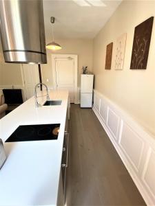 eine Küche mit weißen Arbeitsplatten und einem Kühlschrank in der Unterkunft Elegant Georgian apartment near Clifton Village in Bristol