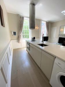 a kitchen with white counter tops and a sink at Elegant Georgian apartment near Clifton Village in Bristol