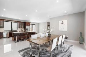 een keuken en eetkamer met een houten tafel en stoelen bij Granada Modern Luxury in Massive Mansion with Heated Pool in Miami