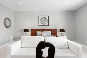 Granada Modern Luxury in Massive Mansion with Heated Pool في ميامي: غرفة معيشة بيضاء مع أريكة بيضاء وسرير