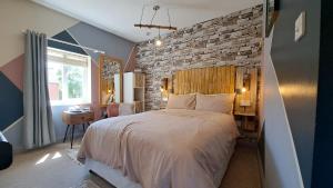 a bedroom with a large bed and a brick wall at Willow Studio in Telford