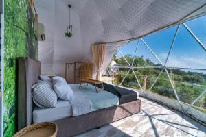 a bedroom with a bed in a tent with large windows at luxury dome tents ikaria ap'esso in Raches