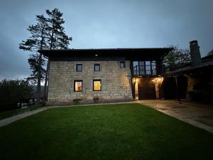 a large stone building with a grass yard in front of it at Къща за гости ,,Горски полъх” in Zaychari