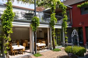 a patio with tables and chairs in a building at Arndt Hotel Garni in Rust