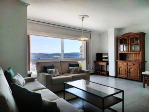 a living room with a couch and a table at Desconectaengalicia El Pescador, vistas al puerto, 200m playa in Portonovo
