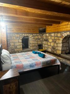 a bed in a room with a stone wall at Къща за гости ,,Горски полъх” 
