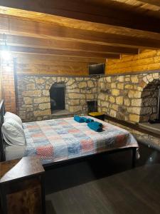 a bed in a room with a stone wall at Къща за гости ,,Горски полъх” in Zaychari