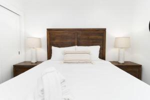 białe łóżko z 2 szafkami nocnymi i 2 lampami w obiekcie North Park Retreat! Trendy & Tranquil 2br/2ba Home w mieście San Diego
